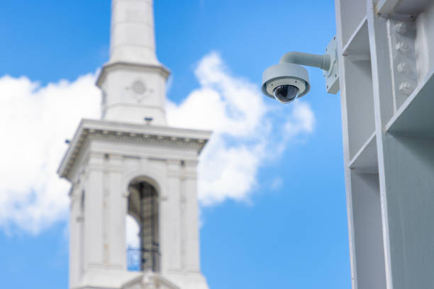 A surveillance camera outside a Christian church building watching for safety.